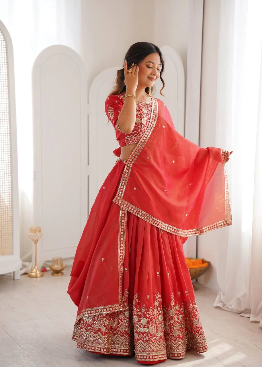 Woman in a red traditional outfit with white embroidery standing in a bright room.